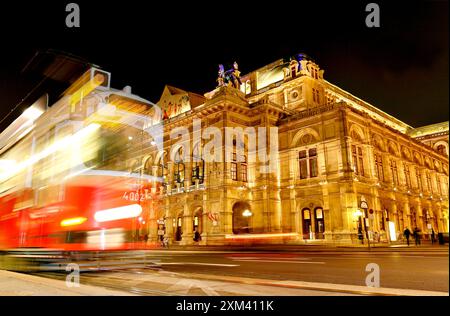 Wiener Staatsoper; Wiener Opernhaus mit Straßenbahn an Ringstraße bei Nacht Stockfoto