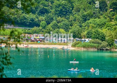 Lago di Ledro, Italien - 21. Juli 2024: Lago di Ledro in Italien mit lebhaftem Strand und Campingplatz. Die Menschen genießen verschiedene Freizeitaktivitäten wie Schwimmen, Sonnenbaden und Kanufahren in der idyllischen und natürlichen Umgebung des Sees *** Lago di Ledro in Italien mit einem belebten Strand und einem Campingplatz. Menschen genießen verschiedene Freizeitaktivitäten wie Schwimmen, Sonnenbaden und Kanufahren in der idyllischen und natürlichen Umgebung des Sees Stockfoto