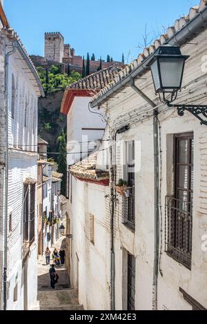 Historische Straße von Albaycin mit Blick auf die majestätische Alhambra in Granada, Andalusien, Spanien an einem sonnigen Tag. Stockfoto