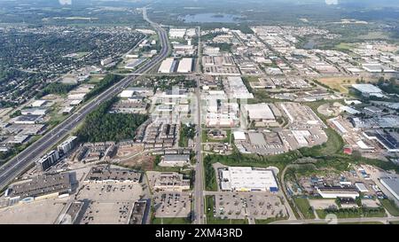 Ein Blick aus der Vogelperspektive auf ein Industriegebiet mit Lagerhäusern, Straßen und Wohnvierteln an einem sonnigen Tag in Waterloo, Ontario, Kanada Stockfoto