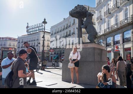 Touristen werden an der Statue „El Oso y El Madroño“ (der Bär und der Erdbeerbaum) auf dem Puerta del Sol-Platz in Madrid fotografiert. Stockfoto