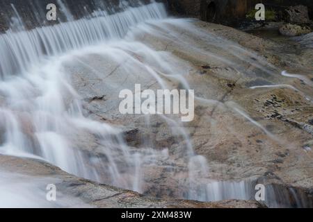 Abstraktes Detail des Wassers, das über Felsen in einem Gebirgsbach in der Nähe von Ballachulish, Glencoe, Schottland, Großbritannien fließt Stockfoto