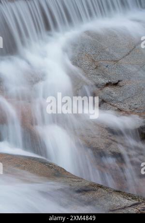 Abstraktes Detail des Wassers, das über Felsen in einem Gebirgsbach in der Nähe von Ballachulish, Glencoe, Schottland, Großbritannien fließt Stockfoto