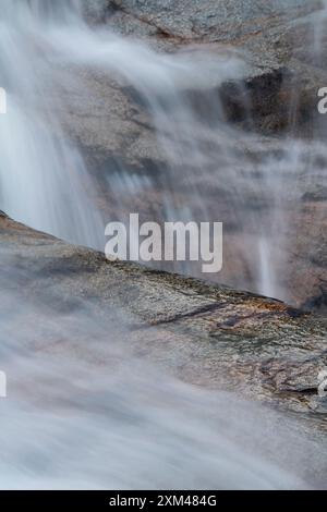 Abstraktes Detail des Wassers, das über Felsen in einem Gebirgsbach in der Nähe von Ballachulish, Glencoe, Schottland, Großbritannien fließt Stockfoto