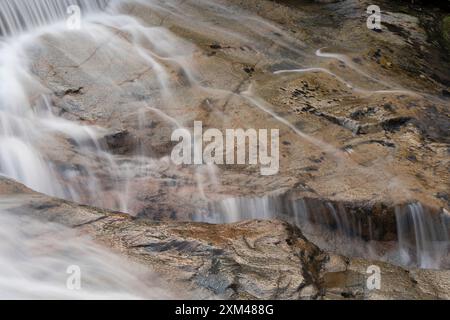 Abstraktes Detail des Wassers, das über Felsen in einem Gebirgsbach in der Nähe von Ballachulish, Glencoe, Schottland, Großbritannien fließt Stockfoto