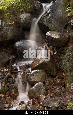 Abstraktes Detail des Wassers, das über Felsen in einem Gebirgsbach in der Nähe von Ballachulish, Glencoe, Schottland, Großbritannien fließt Stockfoto