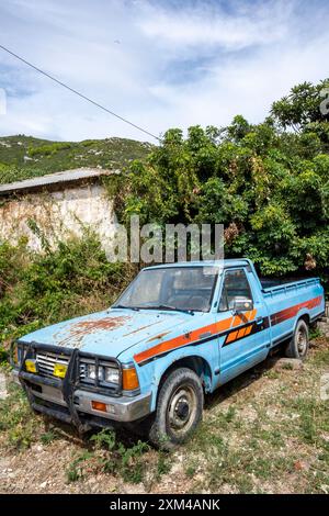 Altes, rostiges Nutzfahrzeug vor einem griechischen Bauernhaus verlassen. Stockfoto