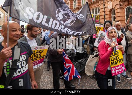 Nahella Ashraf von „Stand Up to Rassiism“ (Kopftuch) führt Protest an. Greater Manchester Stand Up to Racism (GMSUTR) organisierte heute einen Protest in den Büros des Bürgermeisters der Greater Manchester Combined Authority (GMCA) Andy Burnham in der Oxford Street in Manchester. Die Demonstranten verlangten ein sofortiges Ende der rassistischen Polizeigewalt durch die Greater Manchester Police (GMP), nachdem ein kürzlich im Umlauf befindliches Video am Dienstagabend im Terminal 2 des Flughafens Manchester aufgenommen wurde. Das Filmmaterial zeigt einen Offizier, der einem Mitglied der Öffentlichkeit ins Gesicht tritt, gefolgt von dem Offizier, der auf das er der Person stempelt Stockfoto