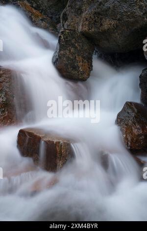 Abstraktes Detail des Wassers, das über Felsen in einem Gebirgsbach in der Nähe von Ballachulish, Glencoe, Schottland, Großbritannien fließt Stockfoto