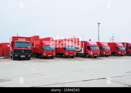 Reihen roter Verteilerwagen am Komplex. In der CCI Coca Cola Soda Fabrik in Taschkent, Usbekistan. Stockfoto