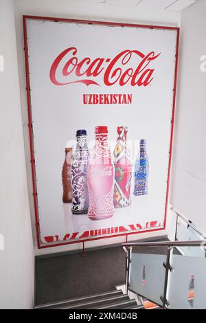 Poster der ikonischen Coca Cola Flasche mit verschiedenen usbekischen Designs, darunter Ikat, Porzellan und Gipsarbeiten. In der CCI Coca Cola Soda Fabrik in Tashke Stockfoto