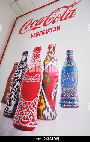 Poster der ikonischen Coca Cola Flasche mit verschiedenen usbekischen Designs, darunter Ikat, Porzellan und Gipsarbeiten. In der CCI Coca Cola Soda Fabrik in Tashke Stockfoto