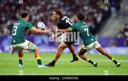 Der Neuseeländer Joe Webber wird vom südafrikanischen IMPI Visser (links) und Tristan Leyds während des Rugby Sivens Matches in Stade de France, Paris, angegriffen. Bilddatum: Donnerstag, 25. Juli. Stockfoto
