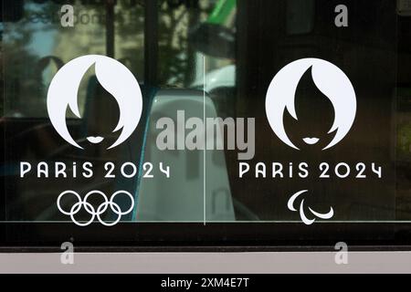 Nahaufnahme der offiziellen Logos von Paris 2024, Symbole der Olympischen Sommerspiele und Paralympischen Spiele in Paris, in weiß auf einer Fensterscheibe gedruckt Stockfoto