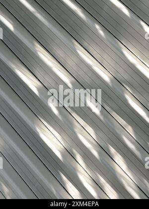 Innenansicht eines modernen Gebäudes mit sonnendurchflutetem Architekturdesign mit geschwungenen Elementen, die dynamische Licht- und Schattenmuster erzeugen und moderne Innovationen hervorheben. Stockfoto
