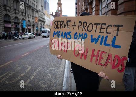 Manchester, Großbritannien. Juli 2024. Ein Demonstrant mit einem Plakat steht vor Andy Burnhams Büro, um gegen die GMP zu protestieren. Ein Mann wurde gewaltsam von einem Polizisten angegriffen, während er am Flughafen Manchester verhaftet wurde. Der Vorfall ereignete sich am Dienstag, als die Polizei in einen Streit zwischen den Bürgern im Terminal 2 des Flughafens eingreift. Andy Barton/Alamy Live News Stockfoto