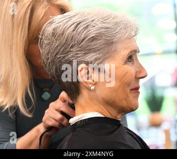 Friseurbesatz am Hals bei älteren Kunden. Das Weibchen hat graue Haare und bekommt einen kurzen Haarschnitt. Stockfoto