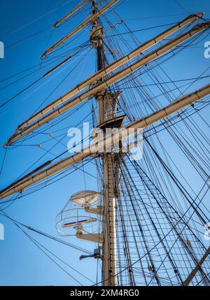 Großer Schiffsmast, Takelage, Yards gegen klaren Himmel. Klassisches Segelschiff mit Krähennest, das zurück in die Ära der Segel geht Stockfoto