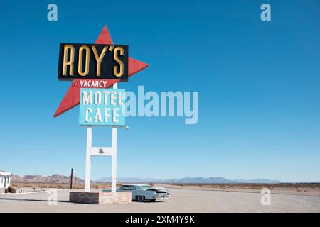 Roy's Motel and Cafe historische Stätte der U.S. Route 66 in der Stadt Amboy in der Mojave-Wüste. Ein verlassenes Motel und ein Auto aus den 1950er Jahren und ein Vintage-Neonschild. Stockfoto