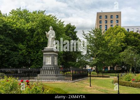 Isaac Watts Monument Memorial Statue vor dem Hintergrund von Bäumen und Gebäuden im Watts Park (West Park), Southampton, Hampshire, England, Großbritannien Stockfoto