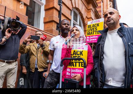 Manchester, Großbritannien. JULI 2024. Frauen sprechen am Mikrofon, während Demonstranten sich zu Demonstrationen gegen ein Video versammelten, das vom Flughafen Manchester veröffentlicht wurde, in dem GMP-Feuerwaffenoffiziere gesehen wurden, die Gewalt gegen Demonstranten einsetzten, wobei der Vorfall an den IPCC verwiesen wurde. Die Demonstranten blockierten die Straßenbahnen und den Verkehr am Petersplatz ohne Polizeieingriff. Die Demonstranten zerstreuten sich nach etwa 2 Stunden. Credit Milo Chandler/Alamy Live News Stockfoto