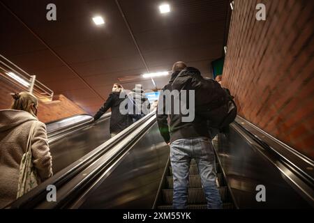Dieses dynamische Bild zeigt Fahrgäste, die auf Rolltreppen im Hauptbahnhof Dortmund klettern. Die Szene spiegelt das tägliche Pendelleben wider, Stockfoto