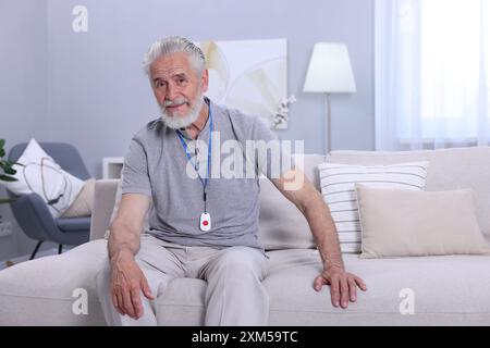 Senior Mann mit Notruftaste zu Hause Stockfoto