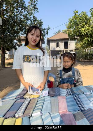 Zwei junge Mädchen, die handgefertigte Tücher verkaufen, in dem kleinen Dorf Angkor Ban, Provinz Battambang, Kambodscha. Stockfoto