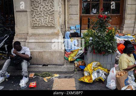 Obdachlose erwarten eine Wohnungslösung vor dem Rathaus des 18. Arrondissements. Dutzende obdachloser Migrantenfamilien verbrachten drei Tage und zwei Nächte an Ort Jules Joffrin vor dem Rathaus des 18. Arrondissements in Paris, um ihr Recht auf Wohnung zu fordern. Eine Polizeieinheit bildete einen Umkreis, der es niemandem erlaubte, das Haus zu verlassen oder zu betreten, was dazu führte, dass die Familien getrennt wurden. Erst am dritten Tag fand die Präfektur Unterkunft in der Ile de France, aber sie wusste nicht, wie lange die Unterkunft dauern würde. Stockfoto