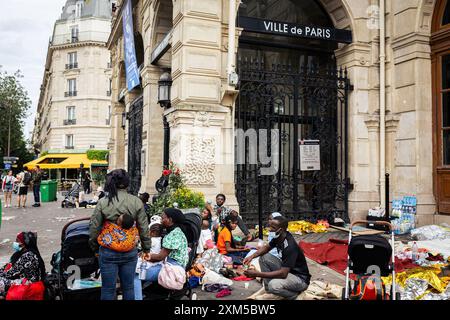 Obdachlose Familien erwarten eine Wohnungslösung vor dem Rathaus des 18. Arrondissements. Dutzende obdachloser Migrantenfamilien verbrachten drei Tage und zwei Nächte an Ort Jules Joffrin vor dem Rathaus des 18. Arrondissements in Paris, um ihr Recht auf Wohnung zu fordern. Eine Polizeieinheit bildete einen Umkreis, der es niemandem erlaubte, das Haus zu verlassen oder zu betreten, was dazu führte, dass die Familien getrennt wurden. Erst am dritten Tag fand die Präfektur Unterkunft in der Ile de France, aber sie wusste nicht, wie lange die Unterkunft dauern würde. Stockfoto