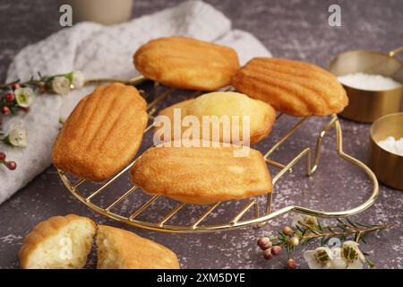 Gitter mit leckeren Madeleinen auf grauem Hintergrund Stockfoto