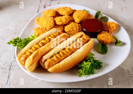 Hot Dog mit Senf und Chicken Nuggets mit Ketchup auf Teller. Stockfoto