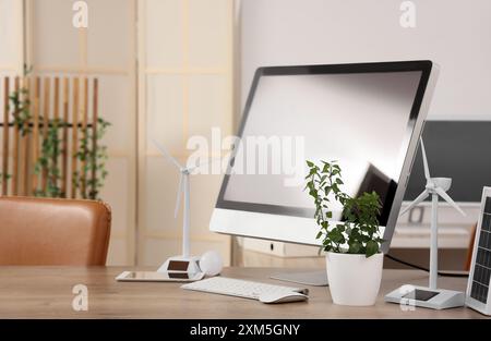 Techniker-Arbeitsplatz mit Computermonitoren, Anlagen- und Windkraftanlagenmodellen im Büro Stockfoto