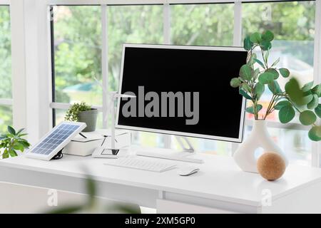 Techniker-Arbeitsplatz mit Computermonitor und Windkraftanlagenmodell im Büro Stockfoto