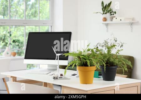 Techniker-Arbeitsplatz mit Computermonitor, Anlagen und Windkraftanlagenmodell im Büro Stockfoto