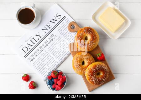 Boarding mit leckeren Bagels, Beeren und Butter auf weißem Holzhintergrund Stockfoto