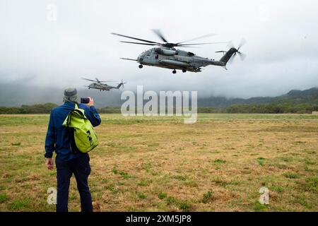 Honolulu, Hawaii, USA. Juli 2024. Ein Mitglied eines deutschen Dokumentarfilms meldet, wie zwei CH-53E Super Hallion Helikopter landen, während US-Marines und peruanische Marinesoldaten die Sicherung eines Einführungspunktes auf der Bellows Air Force Station üben. RIMPAC 2024 (Credit Image: © J. Matt/ZUMA Press Wire) NUR ZUR REDAKTIONELLEN VERWENDUNG! Nicht für kommerzielle ZWECKE! Stockfoto