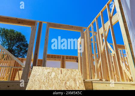 Beim Neubau wird der Rahmen eines unfertigen Innenholzträgers gerahmt Stockfoto