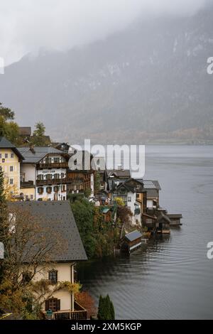 Hallstatt, Österreich - 31. Oktober 2023 : Ein nebeliger Blick auf Hallstatt, Österreich, mit bunten Häusern am Rand eines Sees, eingebettet am Fuße eines M Stockfoto