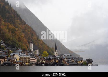 Hallstatt, Österreich - 31. Oktober 2023 : Ein charmantes Dorf vor nebeliger Bergkulisse in Hallstatt, Österreich. Stockfoto