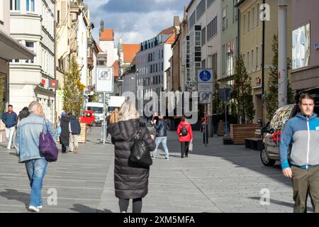 Regensburg, Deutschland - 06. November 2023 : Menschen gehen in Regensburg eine Kopfsteinpflasterstraße hinunter. Stockfoto