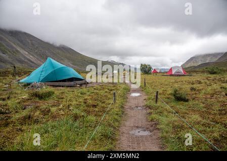 Blick vom Yukon Territory während der Sommerzeit vom Grizzly Lake Campingplatz mit Zelten, Camper und erstaunlichen Berggipfeln und Aussichten im Hintergrund. Stockfoto