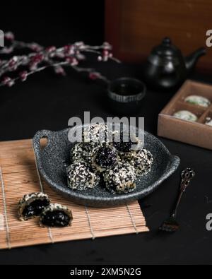 Ein Teller Mochi mit schwarzen Sesamsamen drauf Stockfoto