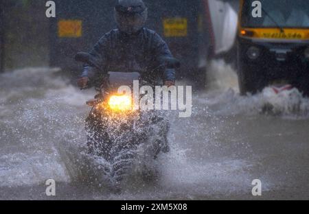 Mumbai, Indien. Juli 2024. MUMBAI, INDIEN - 25. JULI: Menschen, die am 25. Juli 2024 in Mumbai, Indien durch das Holzfällerwasser der Kolonie Aarey fahren. (Foto: Satish Bate/Hindustan Times/SIPA USA) Credit: SIPA USA/Alamy Live News Stockfoto