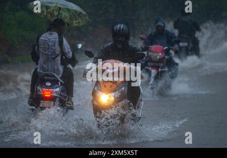 Mumbai, Indien. Juli 2024. MUMBAI, INDIEN - 25. JULI: Menschen, die am 25. Juli 2024 in Mumbai, Indien durch das Holzfällerwasser der Kolonie Aarey fahren. (Foto: Satish Bate/Hindustan Times/SIPA USA) Credit: SIPA USA/Alamy Live News Stockfoto