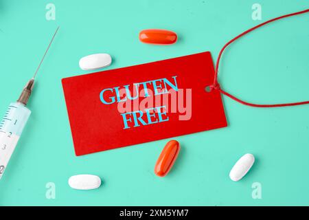 Phrase Glutenfrei auf einer roten Karte in einer Zusammensetzung mit Tabletten, Vitaminen und einer Spritze geschrieben. Stockfoto