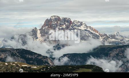 Tre Cime Circuit: Schneebedeckte Pfade und dramatische Dolomitengipfel, die teilweise von Wolken verdeckt sind Stockfoto