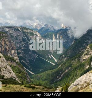 Die Pracht der Dolomiten im Juni: Verschneite Tre Cime Circuit mit Gipfeln, die teilweise von wirbelnden Wolken verdeckt sind. Stockfoto