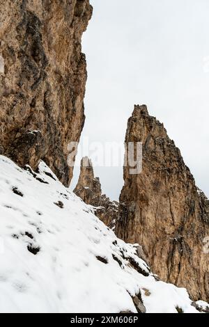 Juni in den Dolomiten: Wandern auf den schneebedeckten Wegen der CIR-Gruppe vor der Kulisse der wirbelnden Wolken Stockfoto