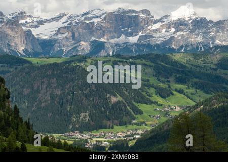 Vom Wanderweg Sella Group aus bestaunen Sie Colfosco, eingebettet in eine Kulisse hoch aufragender Berge, die die atemberaubende alpine Schönheit von Th zeigt Stockfoto